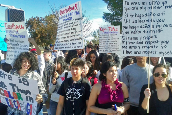 Crowd of young brown people carrying protest signs
