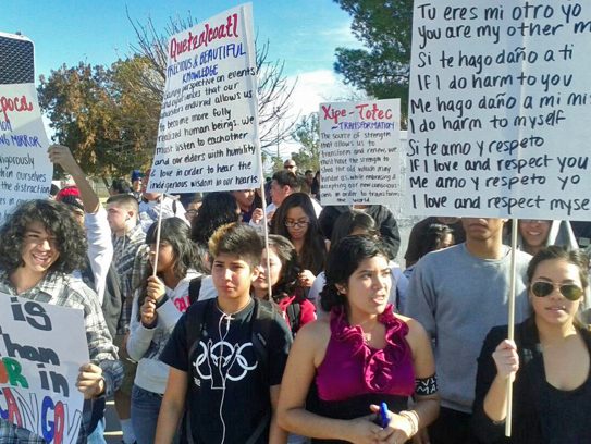 Crowd of young brown people carrying protest signs