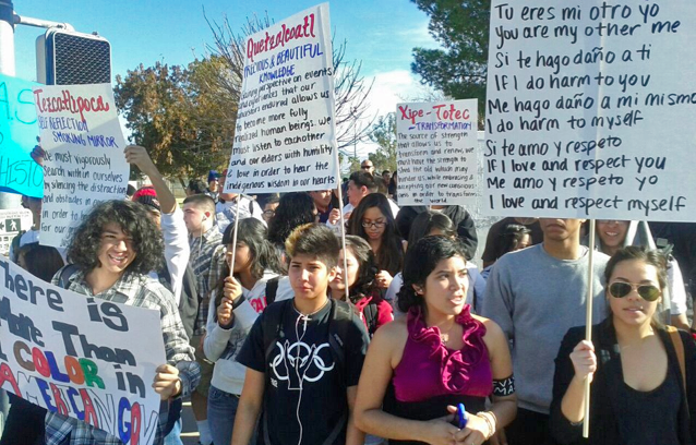 Crowd of young brown people carrying protest signs